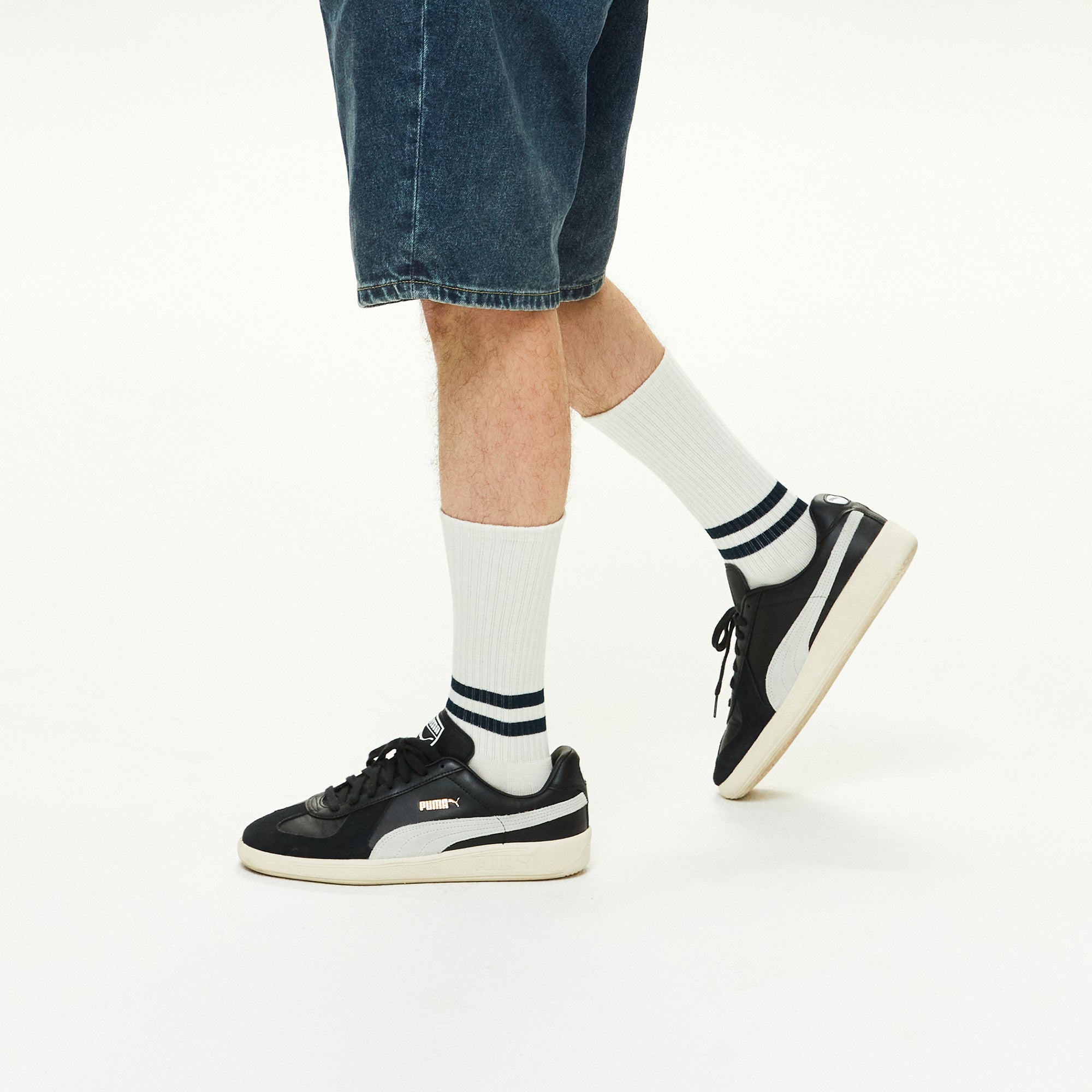 A man wearing a pair of black and white sneakers.
