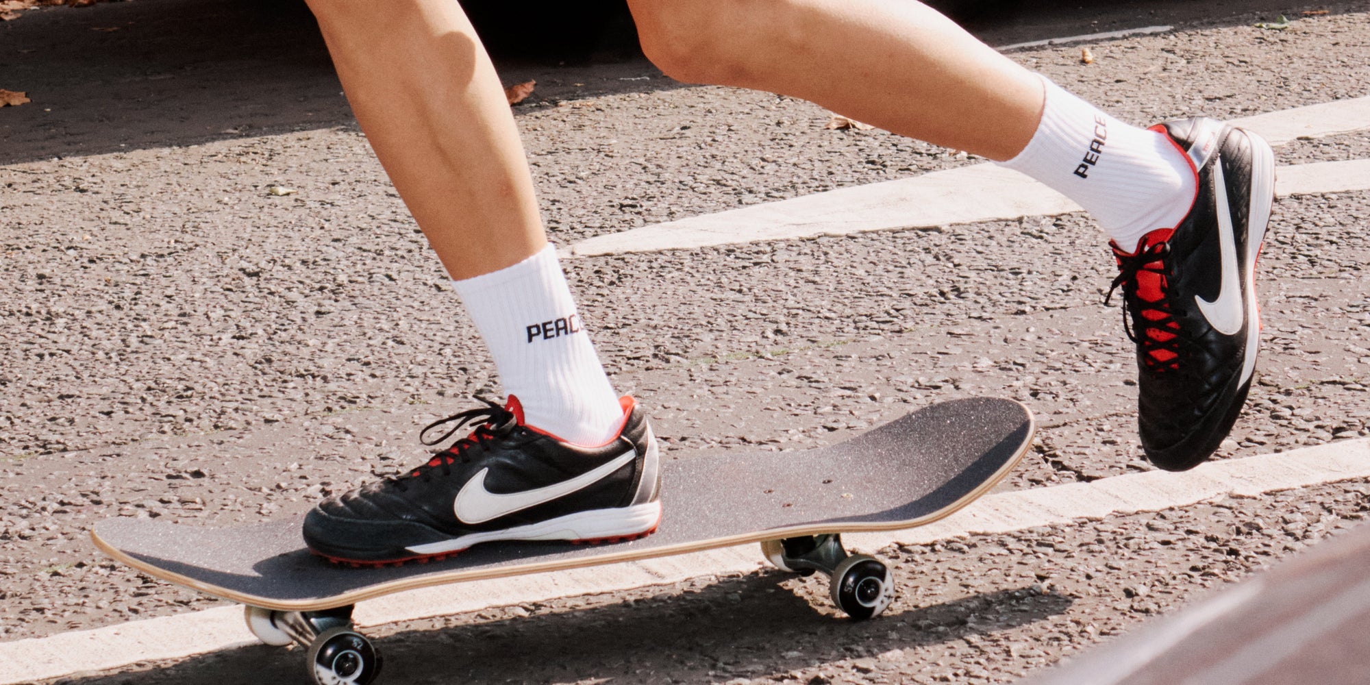 A person riding a skateboard in a parking lot.