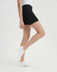 A woman in black shorts and white socks.
