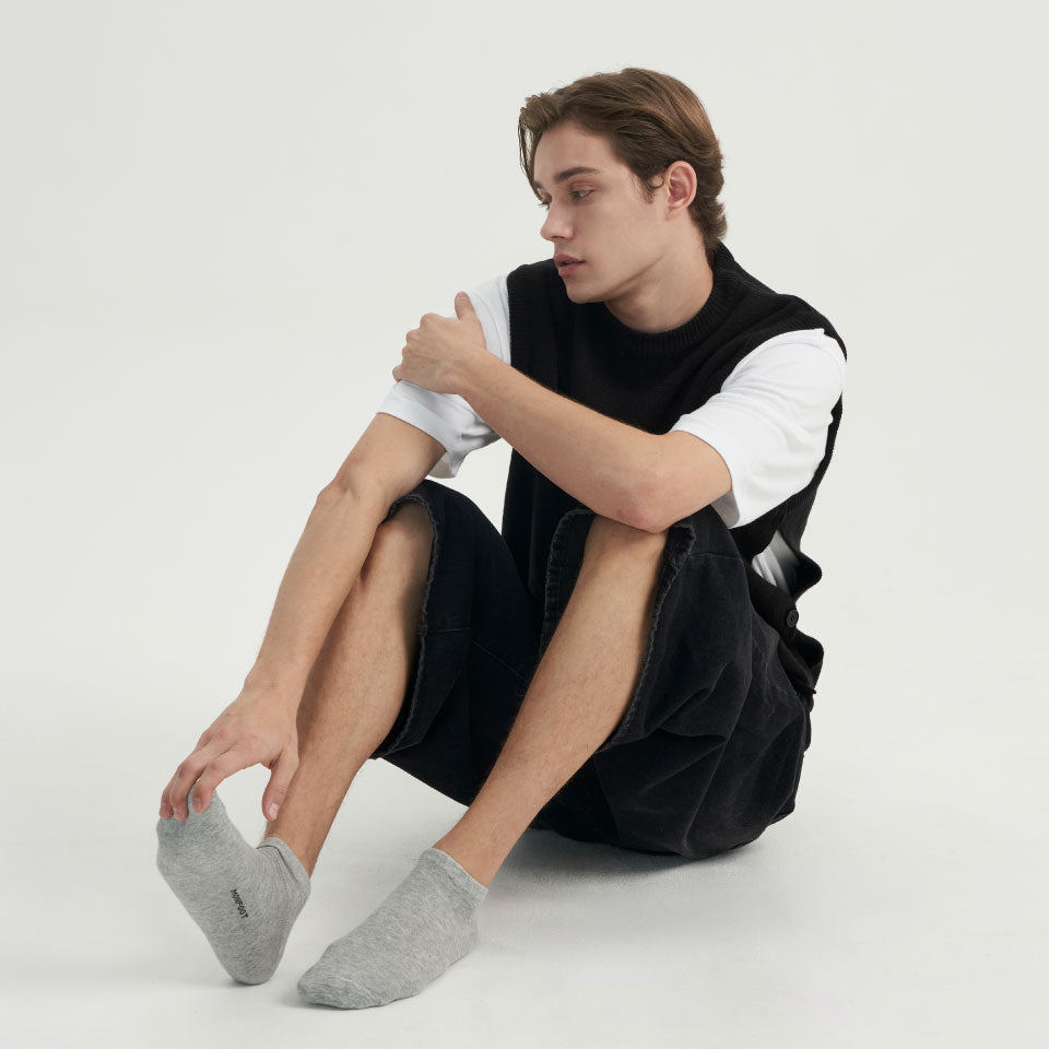 A man sitting on the ground with his legs crossed.