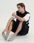 A man sitting on the ground with his legs crossed.
