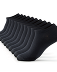 A dozen of black socks sitting on top of each other.