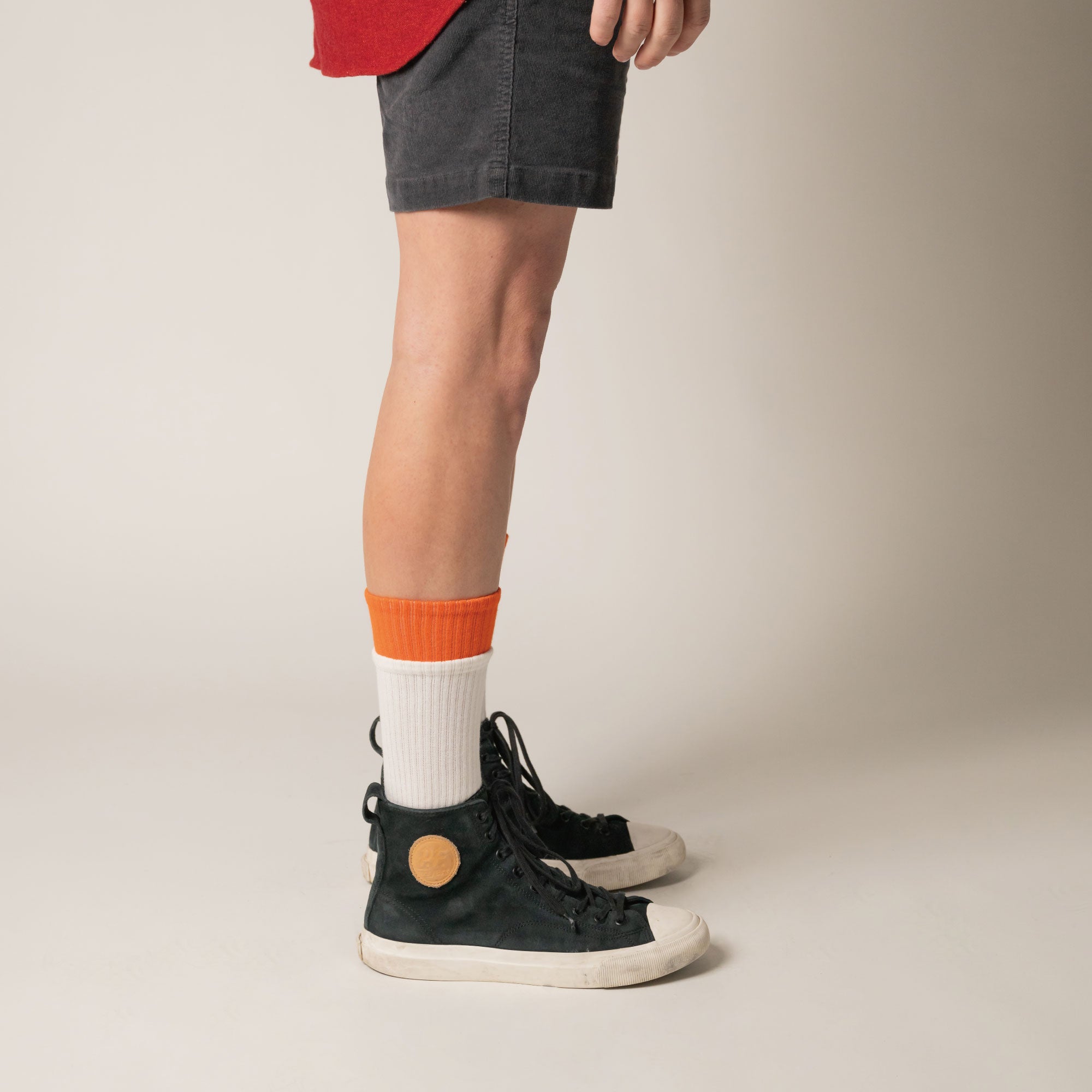 A man wearing a red shirt and black shorts.