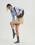 A woman in a skirt and shirt is posing for a picture.