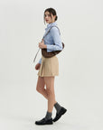A woman in a blue shirt and tan skirt.