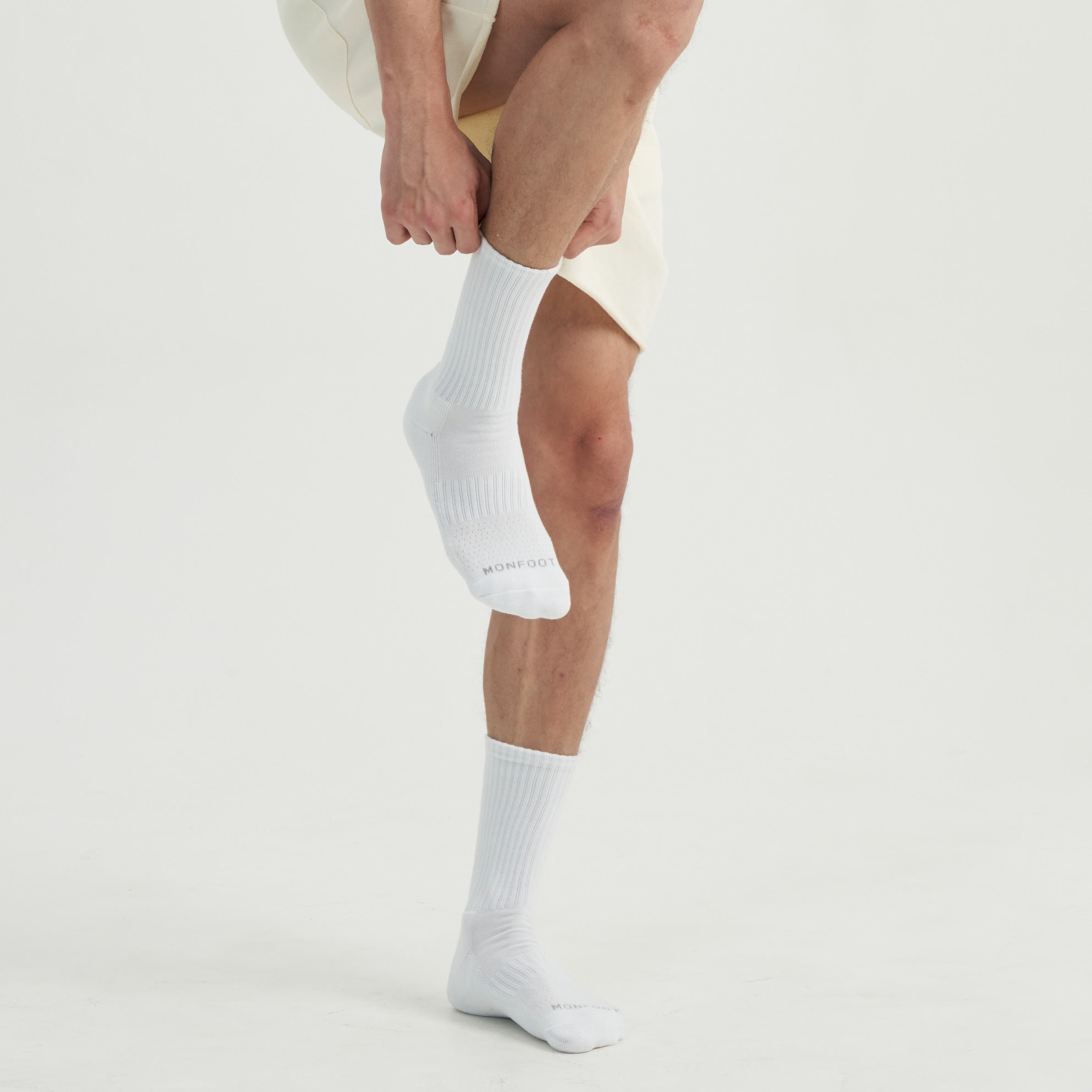 A man in a white shirt and white socks.