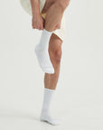 A man in a white shirt and white socks.