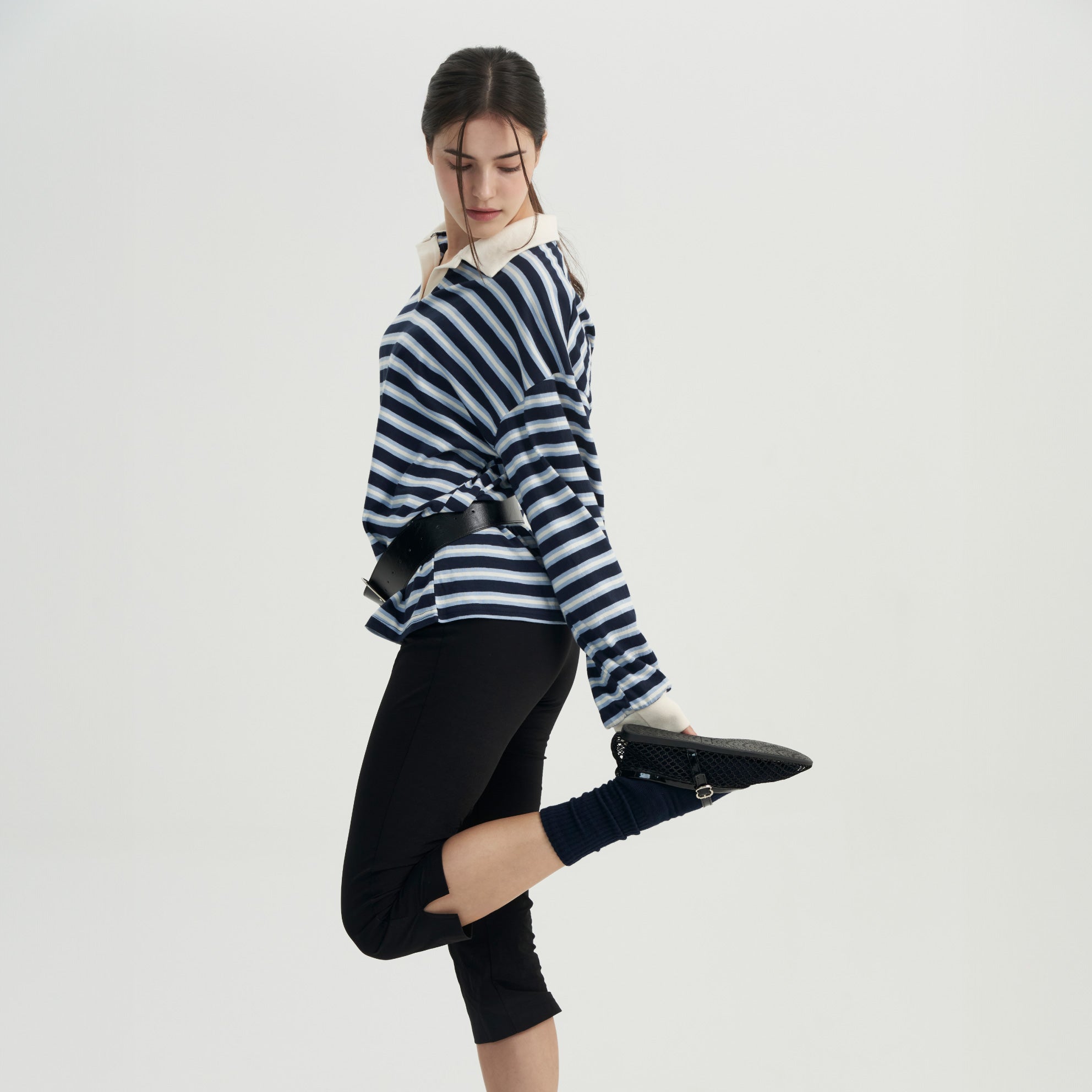 A woman in a striped shirt and black pants.