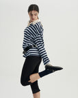 A woman in a striped shirt and black pants.