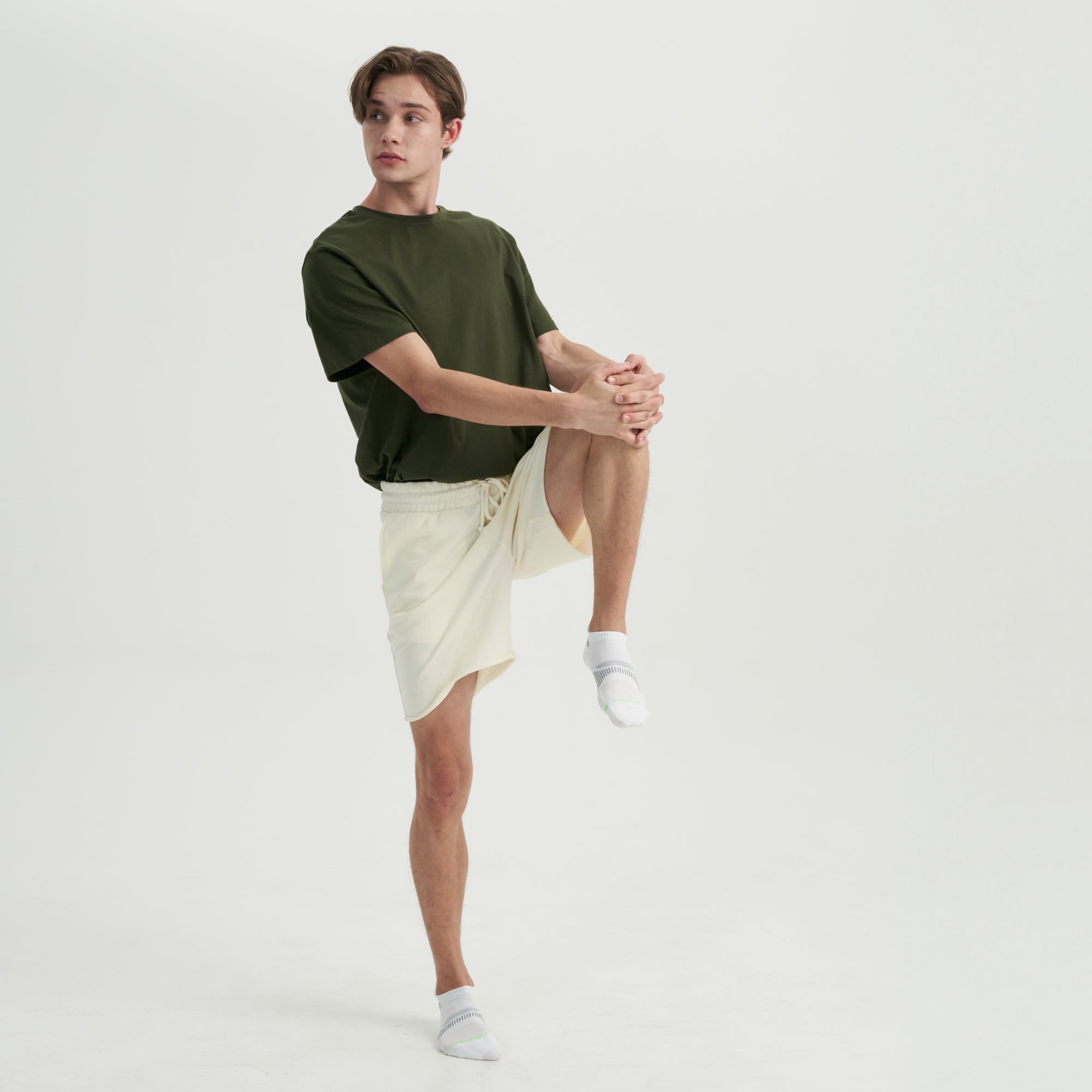 A man in a green shirt and white shorts.