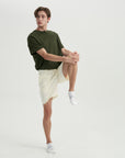 A man in a green shirt and white shorts.