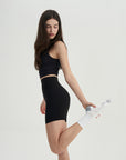 A woman in a black top and a black skirt.