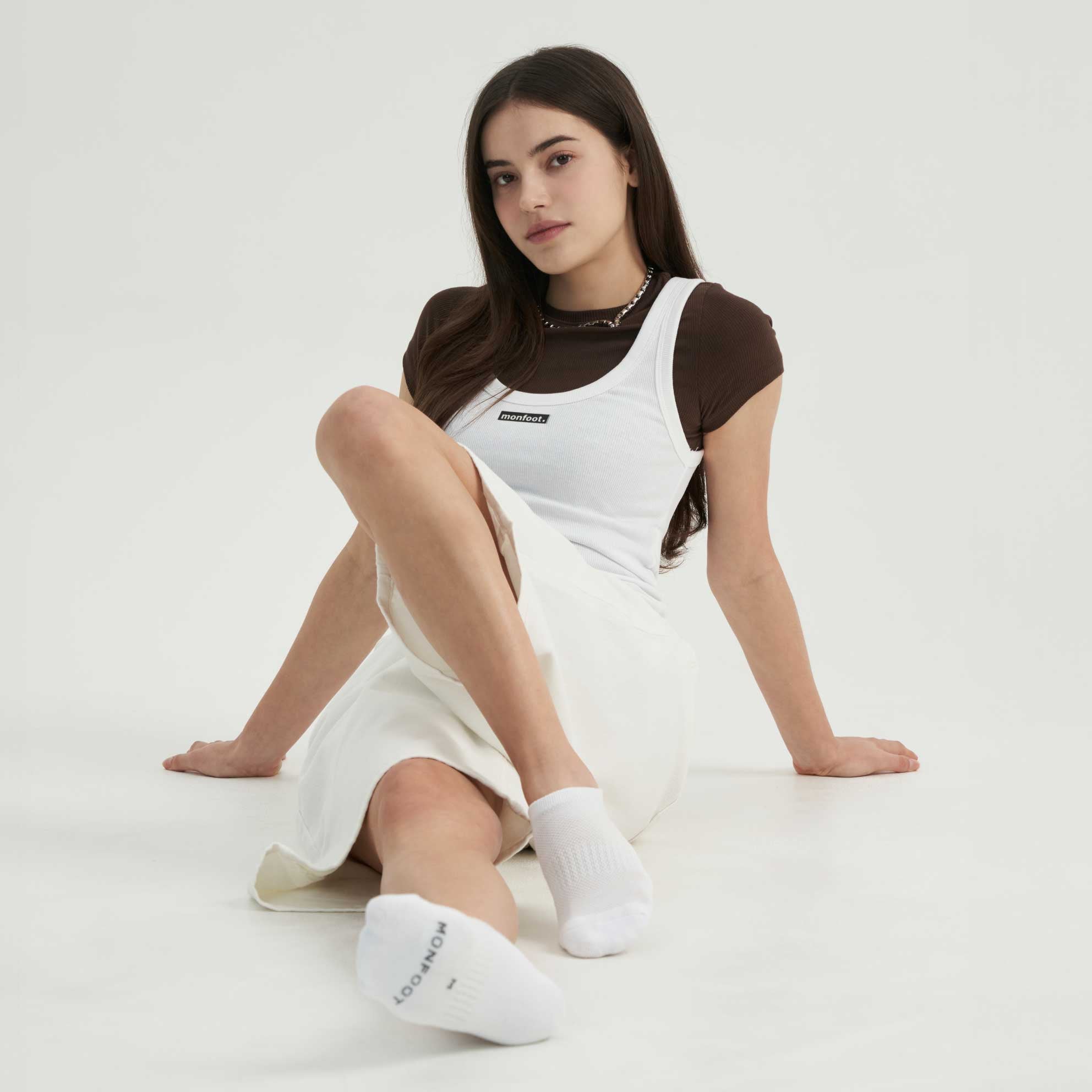 A woman sitting on the ground with her legs crossed.