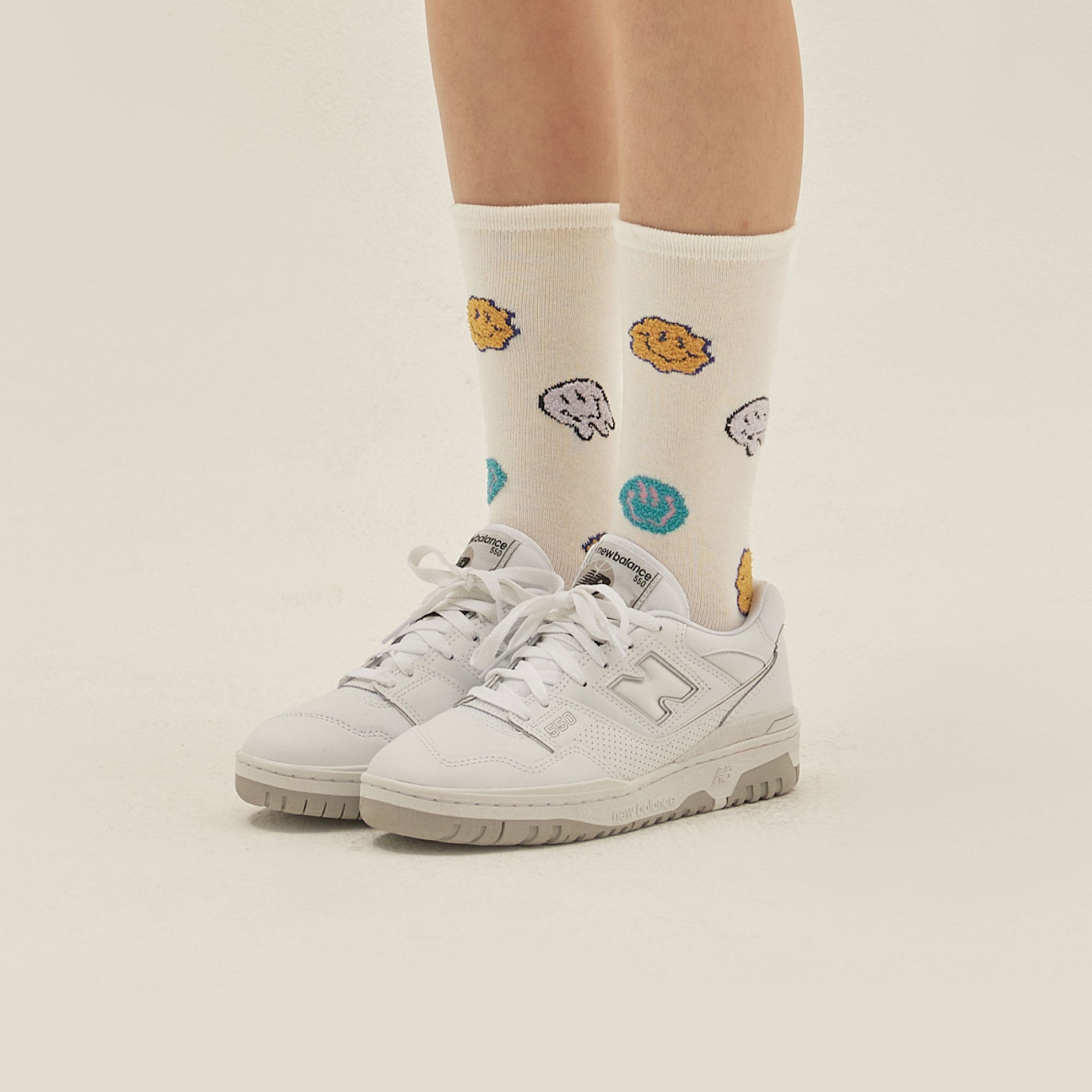 A person wearing a pair of white tennis shoes.