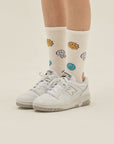 A person wearing a pair of white tennis shoes.