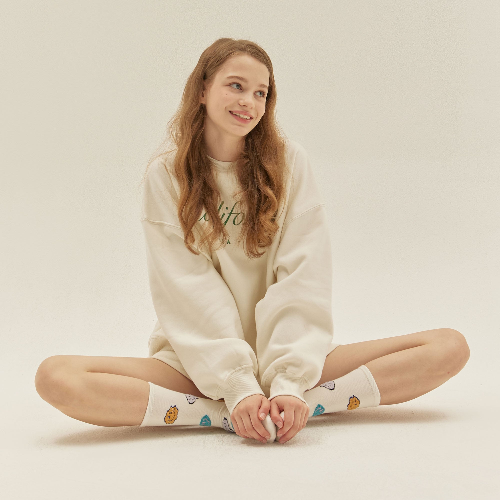 A woman sitting on the floor with her legs crossed.
