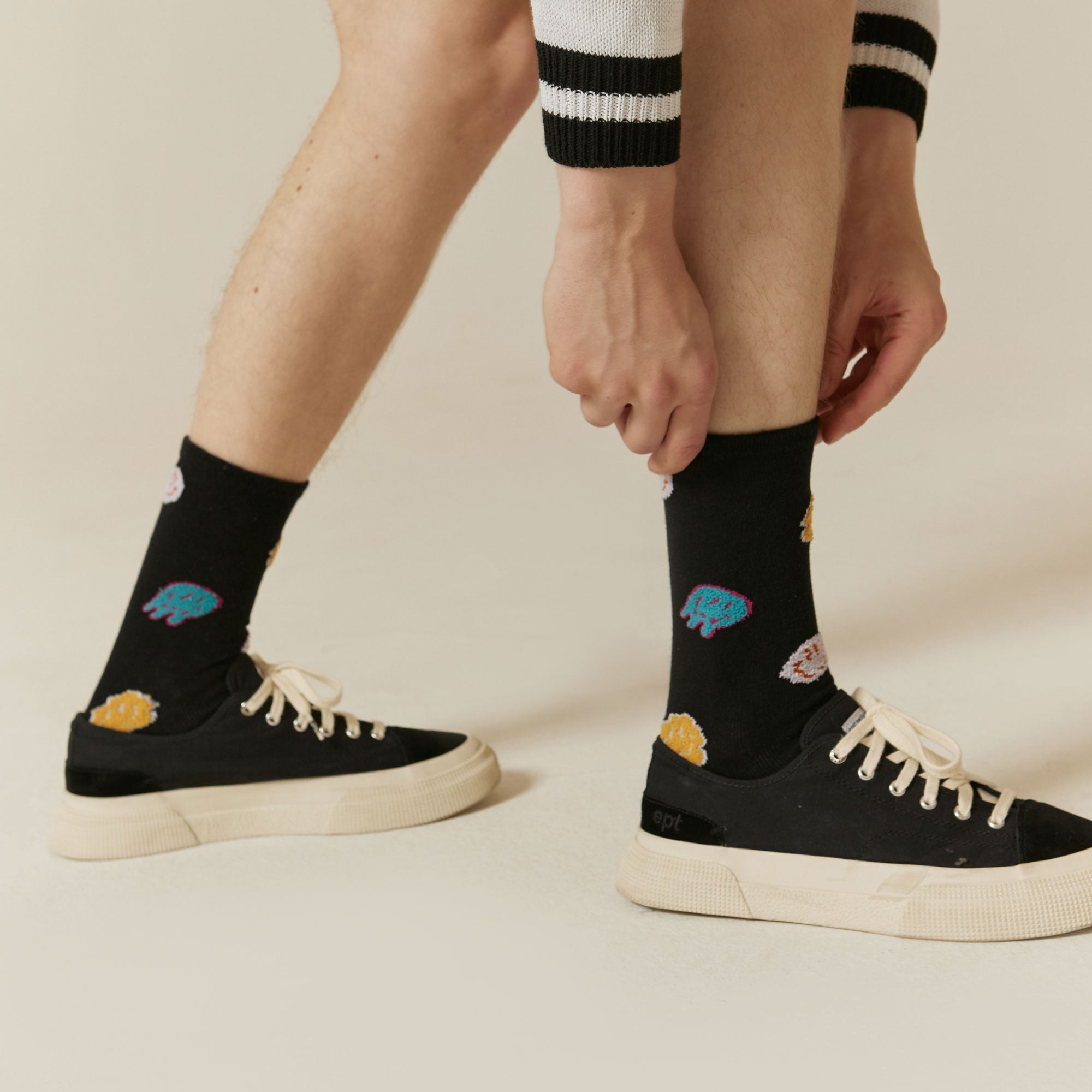 A man tying his shoes with a pair of socks.