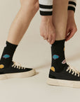 A man tying his shoes with a pair of socks.