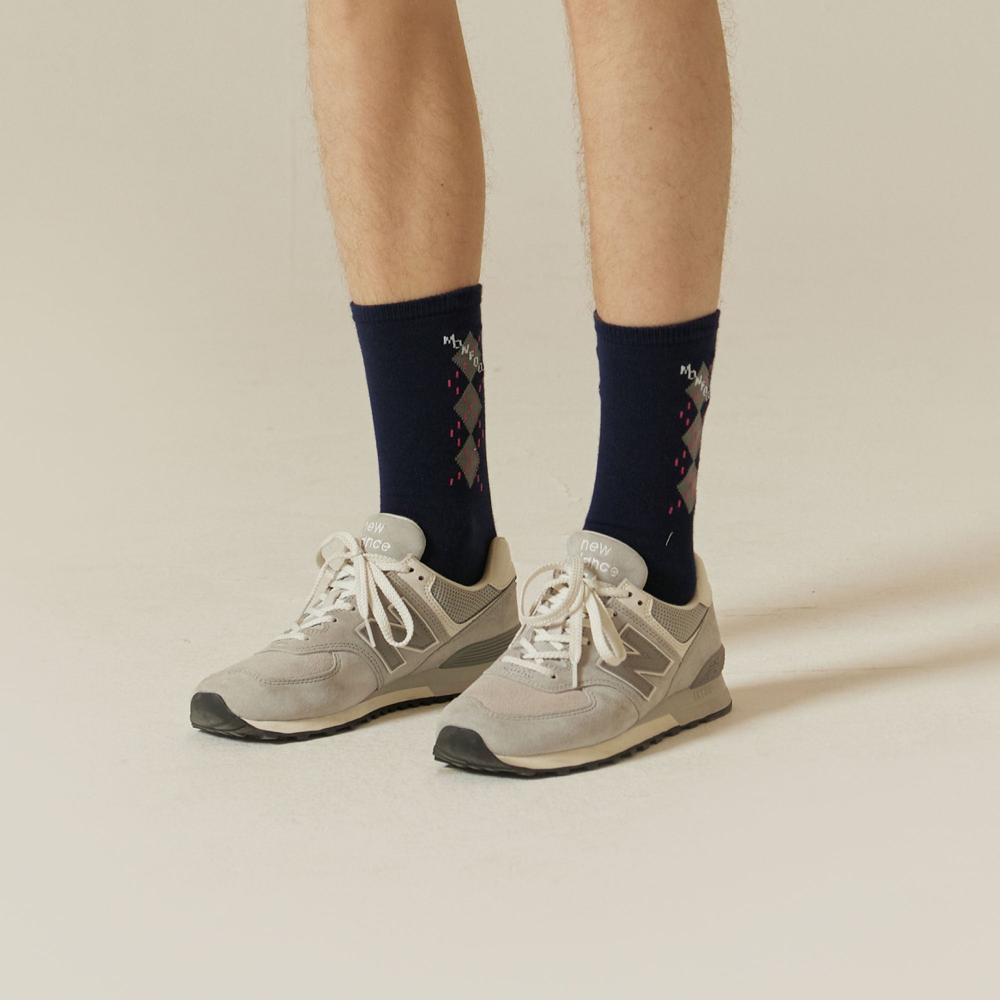 A man wearing a pair of gray sneakers.