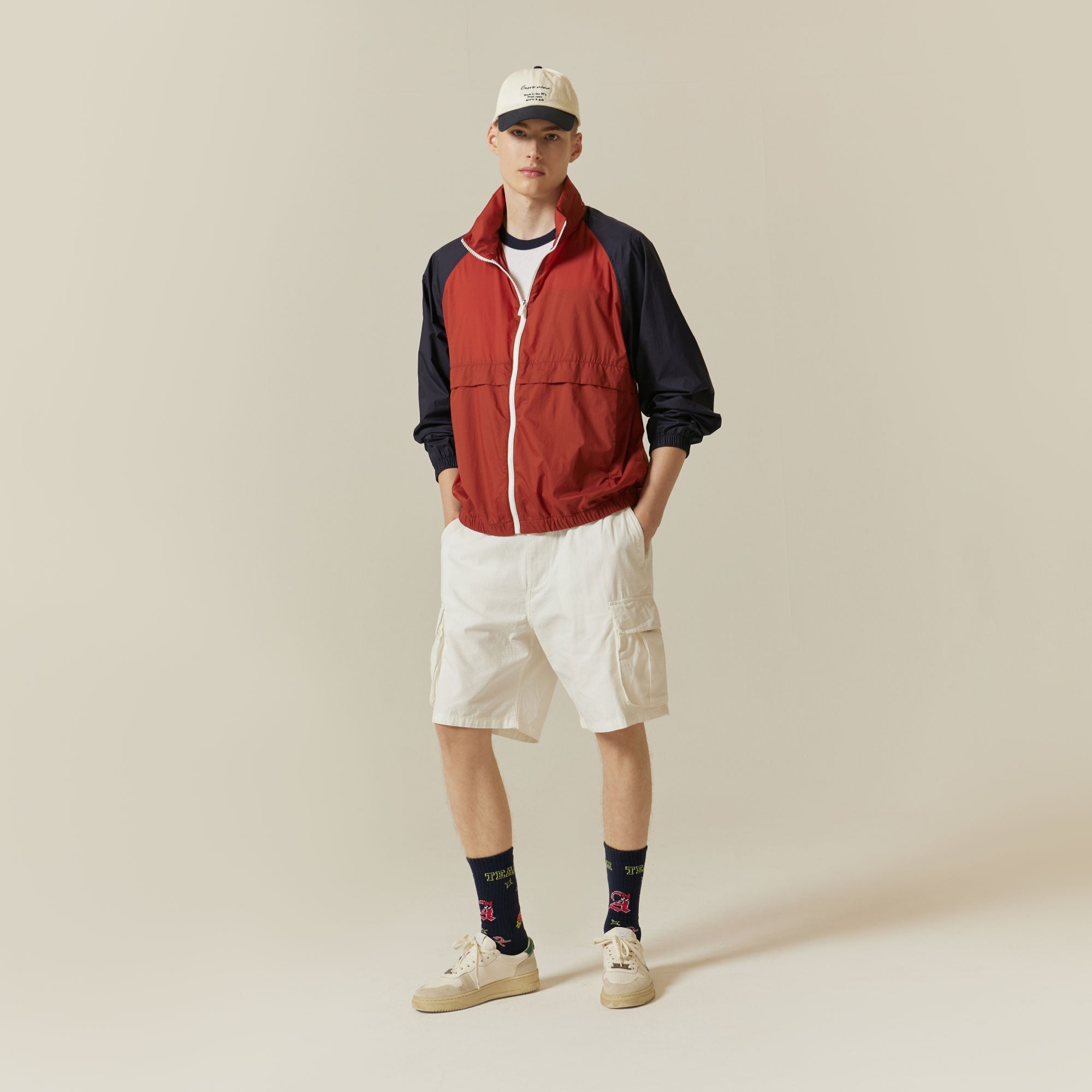 A man in a red jacket and white shorts.