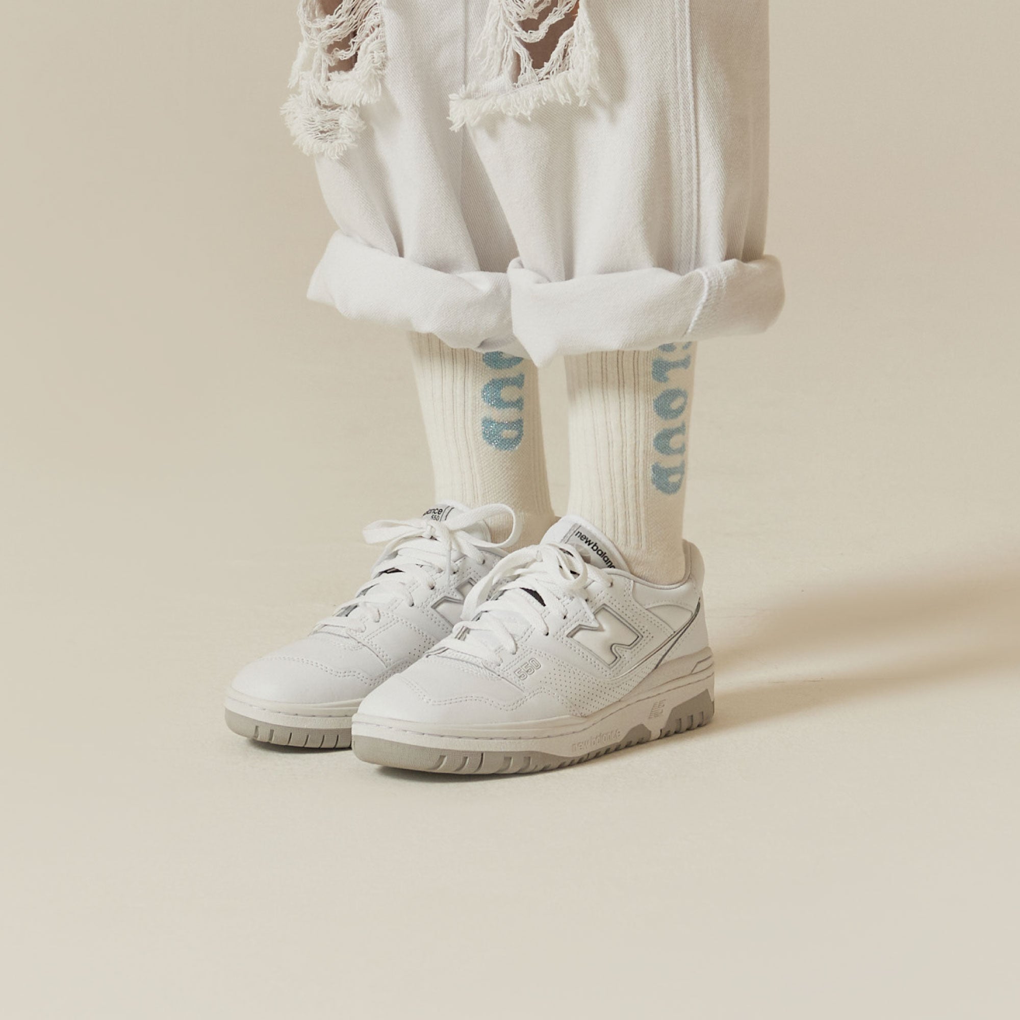 A person wearing white sneakers and white pants.