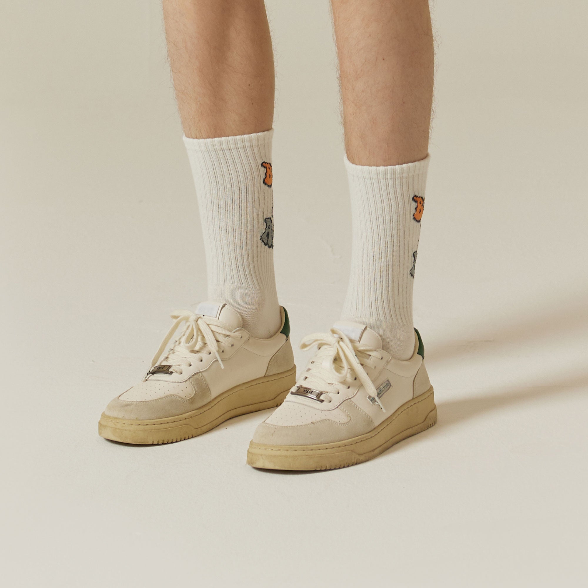 A person wearing a pair of white tennis shoes.