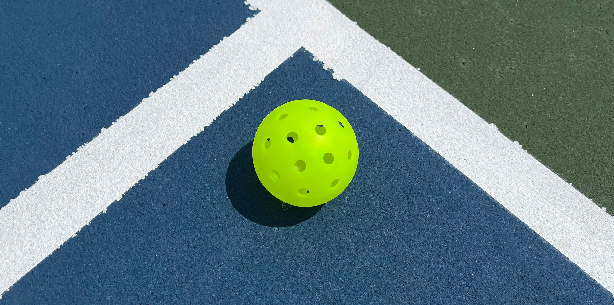 A tennis ball sitting on a tennis court.