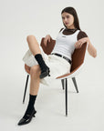 A woman sitting in a chair with her legs crossed.