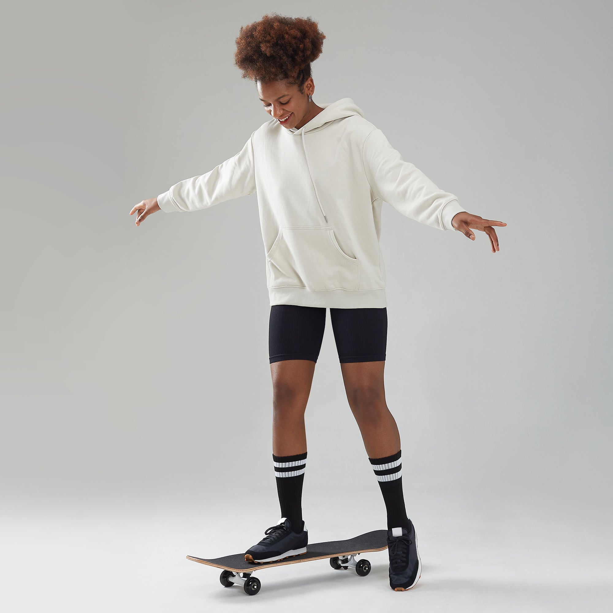 A young man riding a skateboard on a white surface.