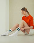 A woman sitting on the floor with her legs crossed.