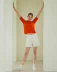 A woman standing in a room with her arms in the air.