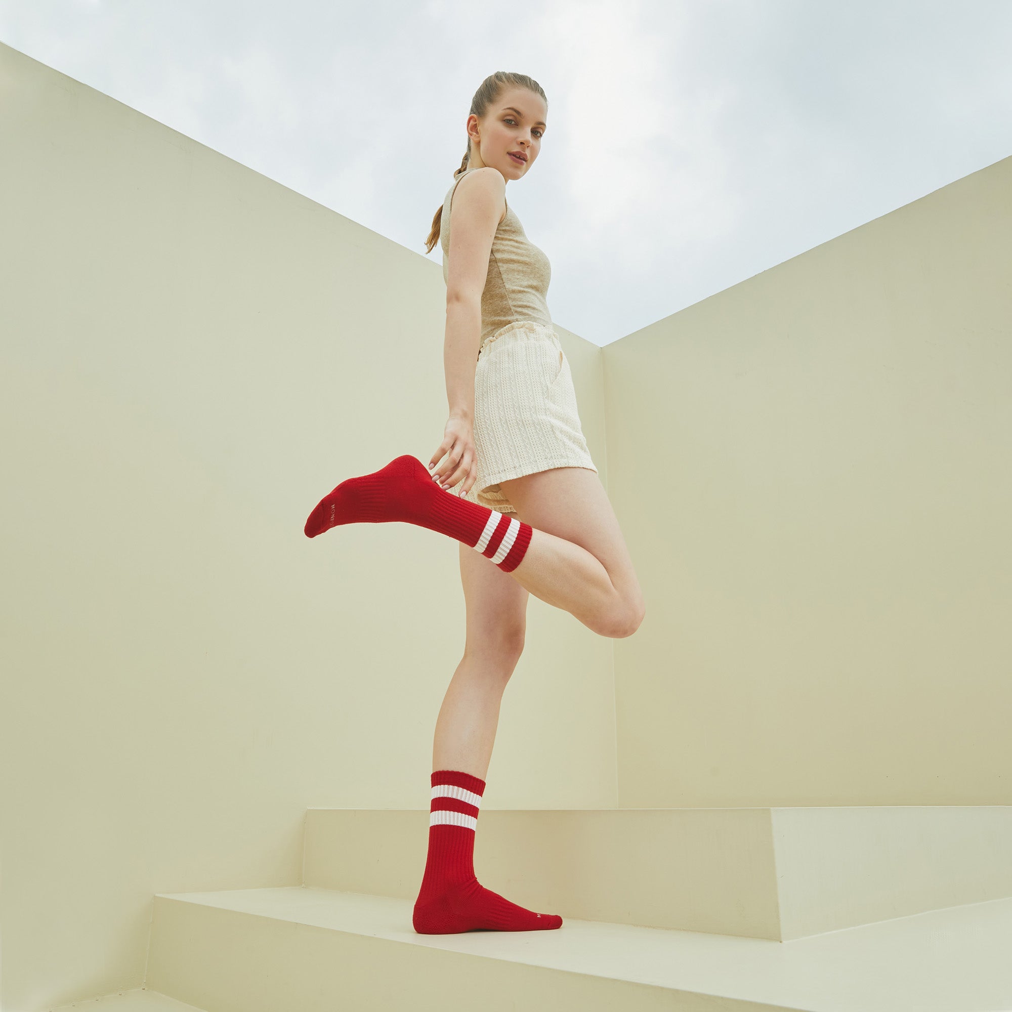 A woman standing on some steps with her legs crossed.