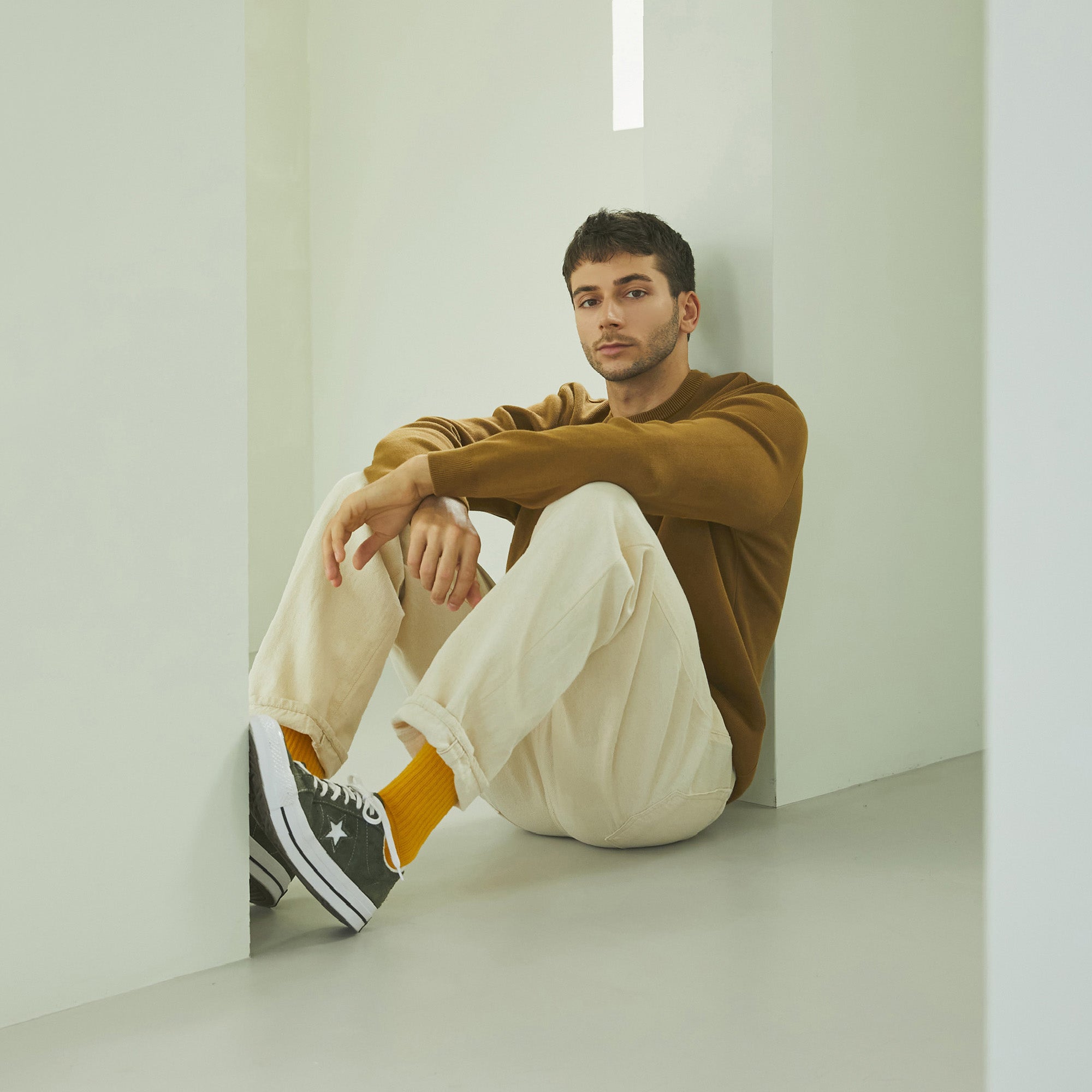 A man sitting on the floor with his legs crossed.