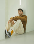A man sitting on the floor with his legs crossed.