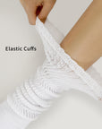 A pair of white socks with a woman's arm wrapped around them.
