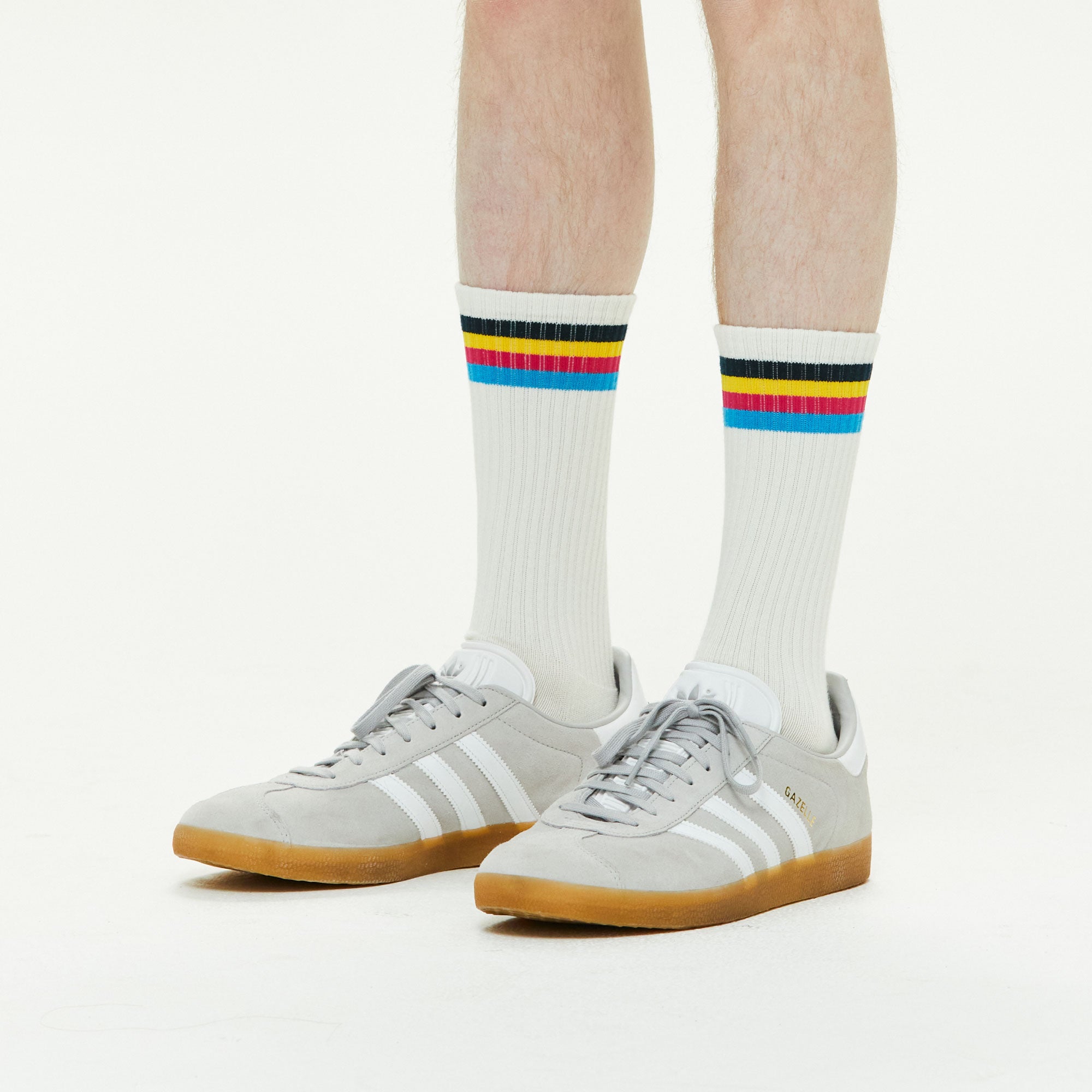 A man wearing a pair of white adidas sneakers.
