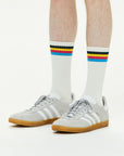 A man wearing a pair of white adidas sneakers.