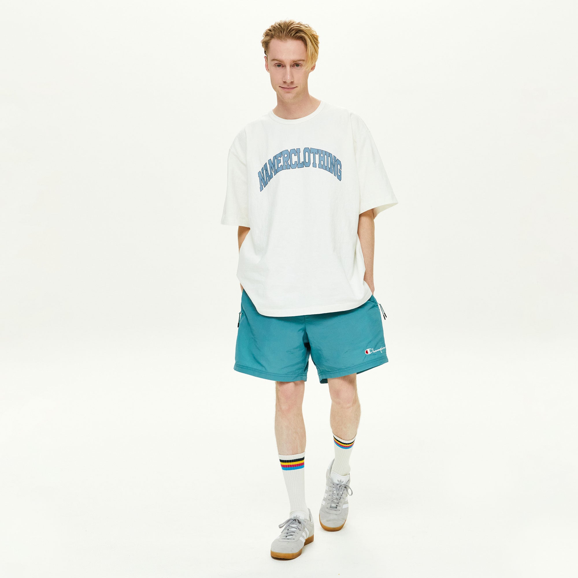 A man in a white t - shirt and blue shorts.