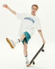 A young man riding a skateboard while holding a skateboard.