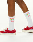 A close up of a person wearing red shoes.