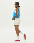 A woman in white shorts and a blue tank top.