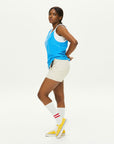 A woman in a blue shirt and white skirt.