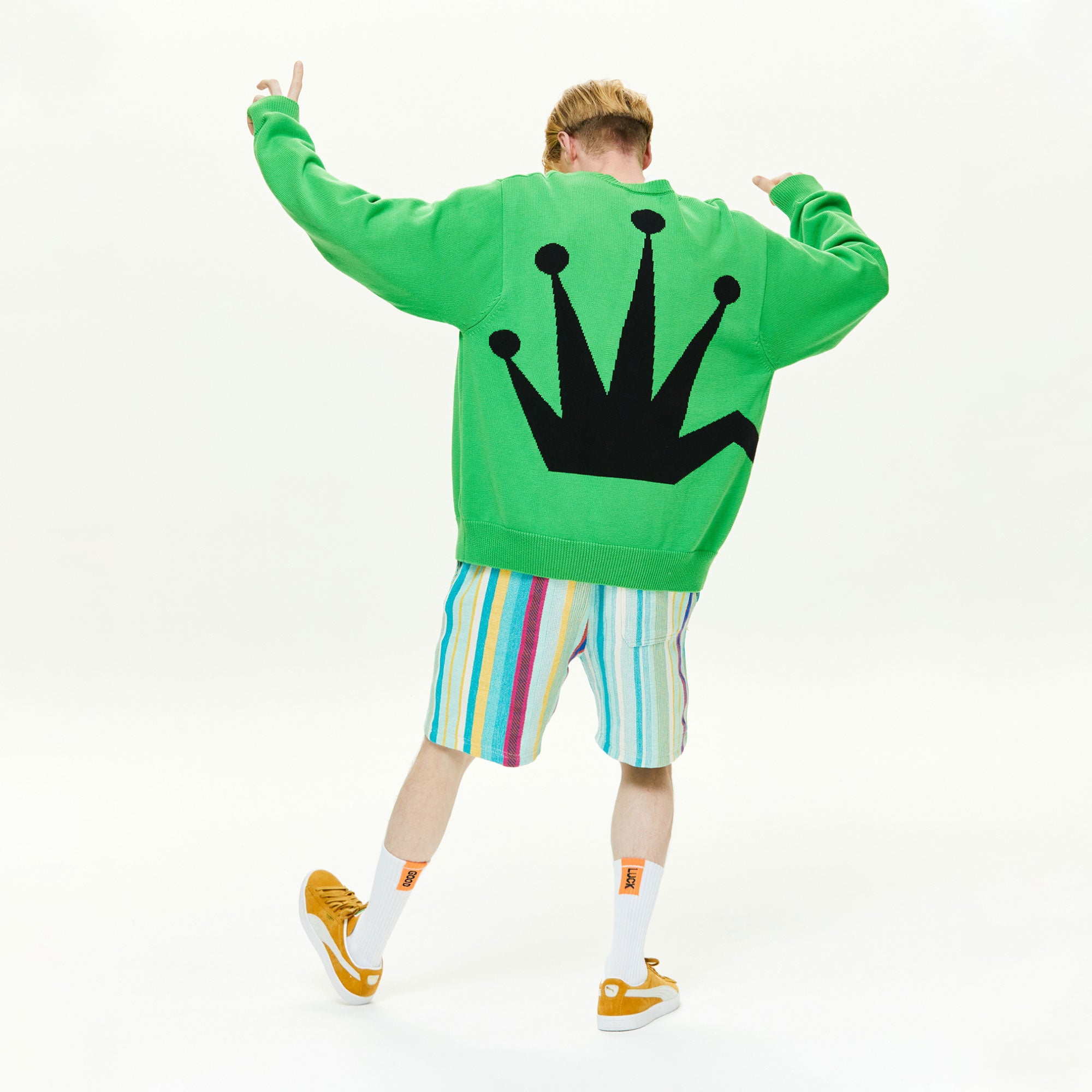 A man wearing a green sweatshirt with a crown on it.
