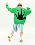 A man wearing a green sweatshirt with a crown on it.