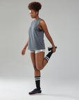 A woman in shorts and a tank top posing for a picture.