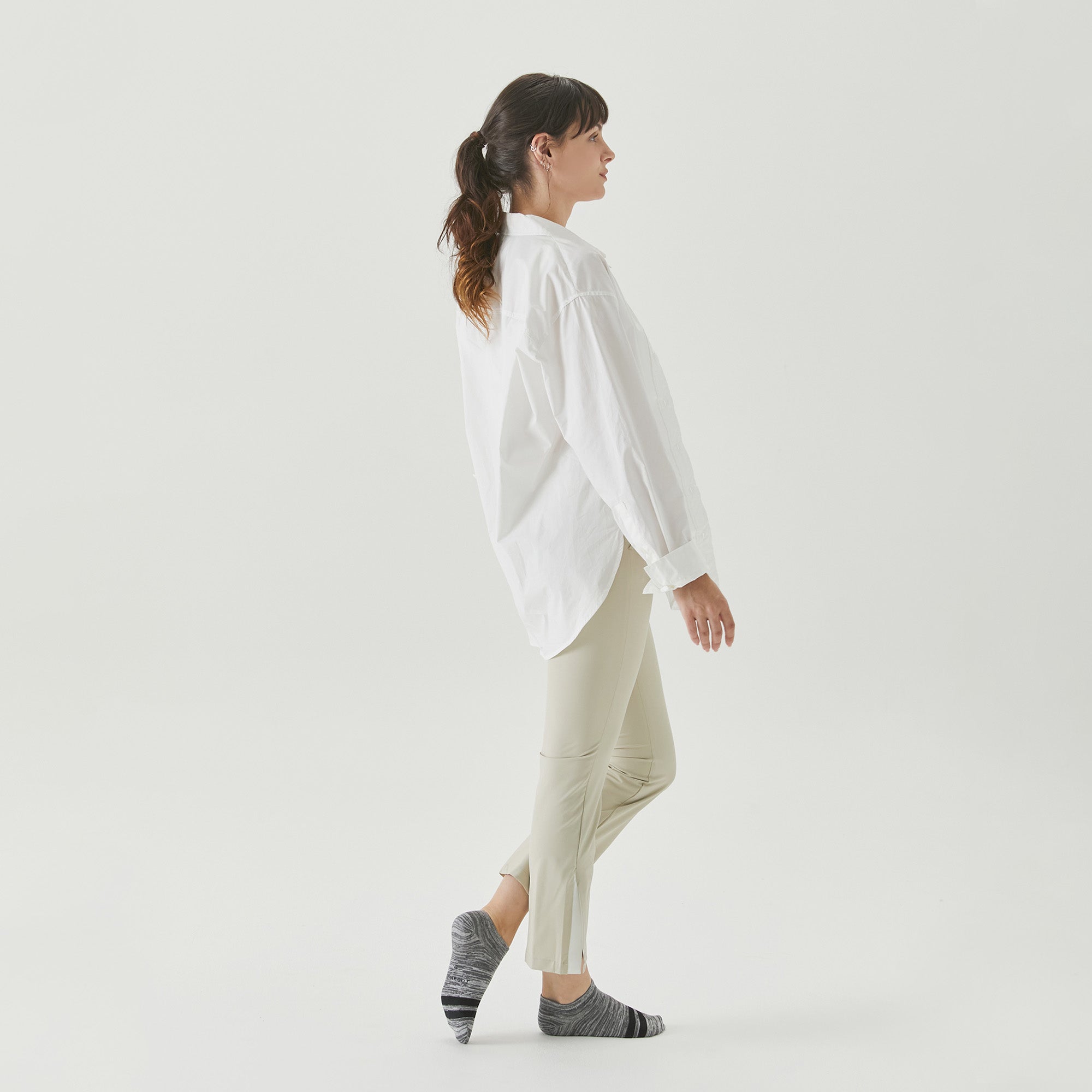 A woman in a white shirt is walking.