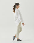 A woman in a white shirt is walking.
