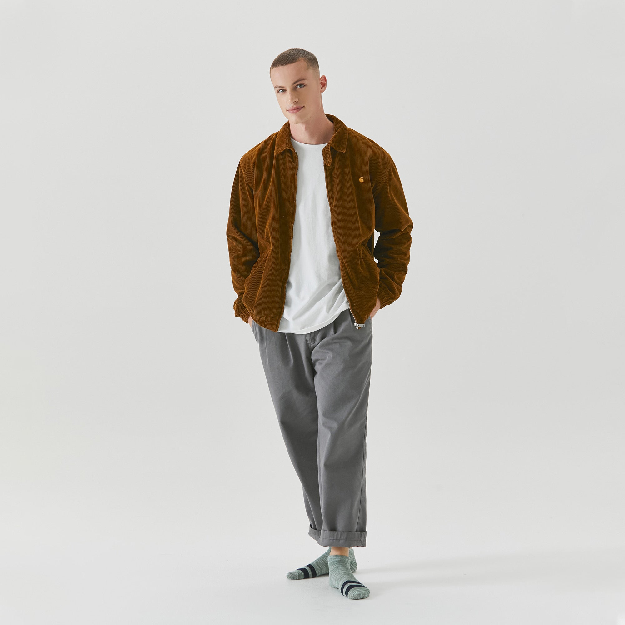 A man in a brown jacket and grey pants.