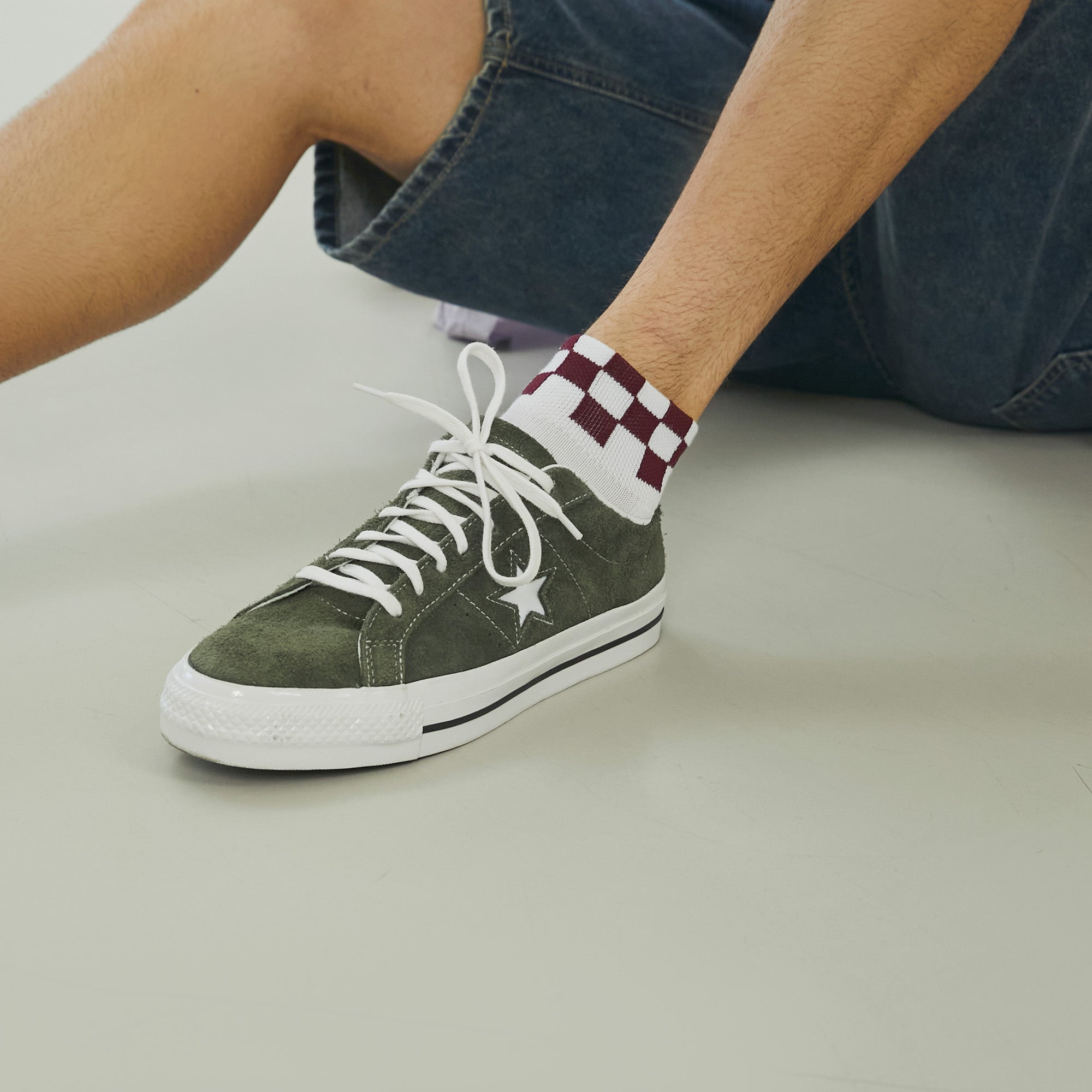 A man sitting on the ground with his legs crossed.