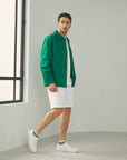 A man in a green shirt and white shorts.